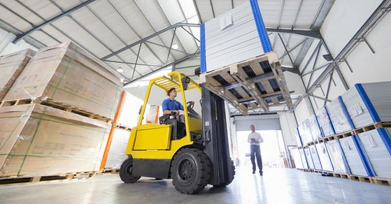 Cuidados no Transporte de Pallets para não causar acidentes e avarias: imagem de uma empilhadeira carregando carga em pallets