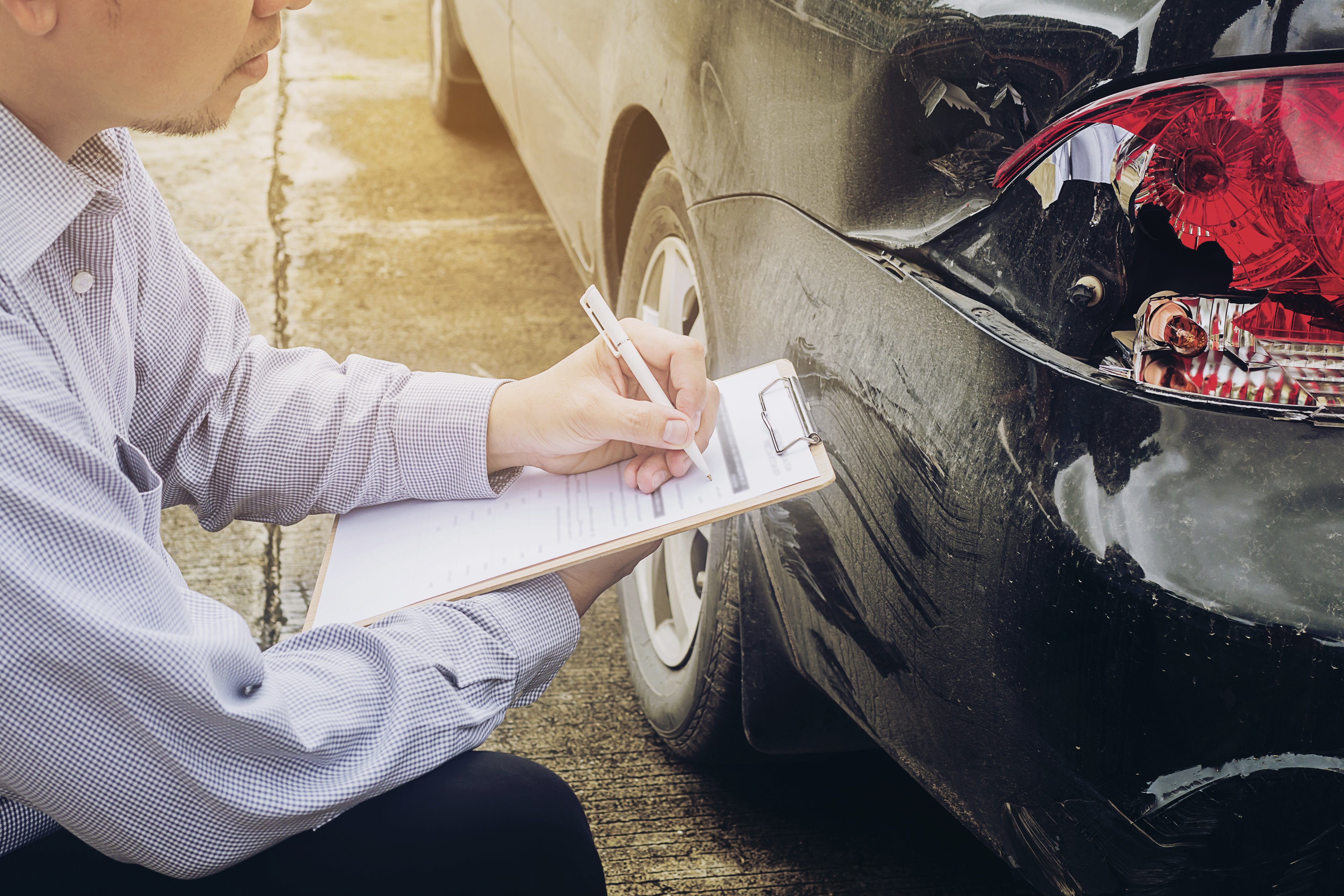 homem fazendo a avaliação de sinistro de carro