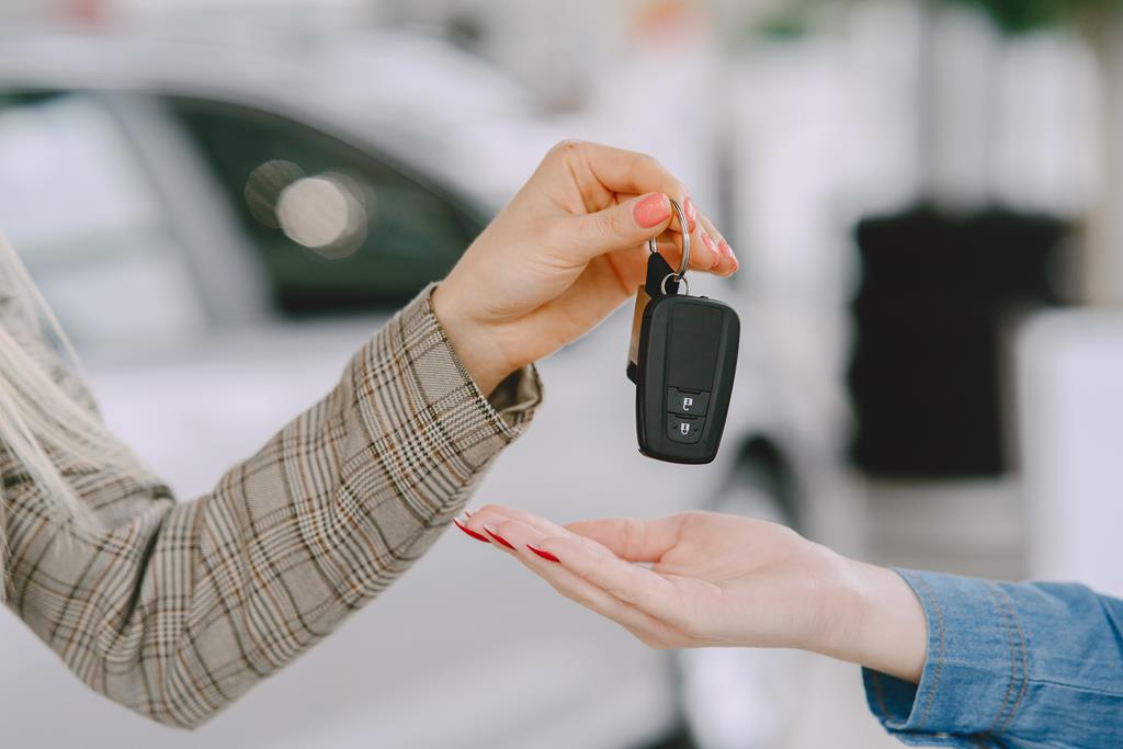 mão entregando as chaves de um carro para outra pessoa