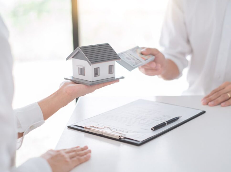 Direitos sobre imóvel: pessoa fazendo pagamento após ter comprado uma casa. Imagem ilustra o pagamento da transação.